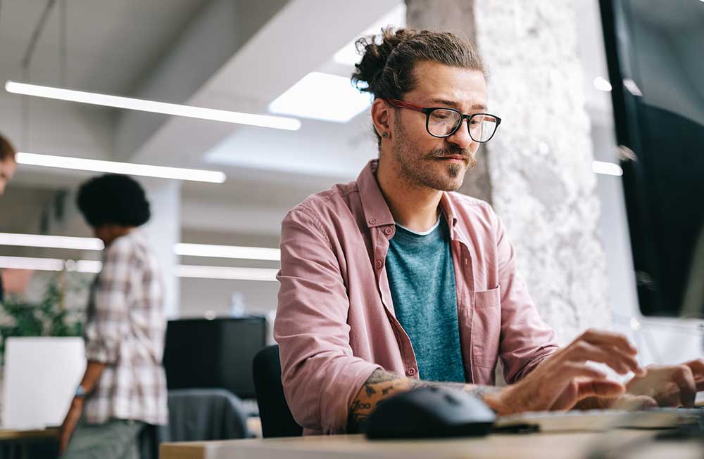 Man at desk working on computer.